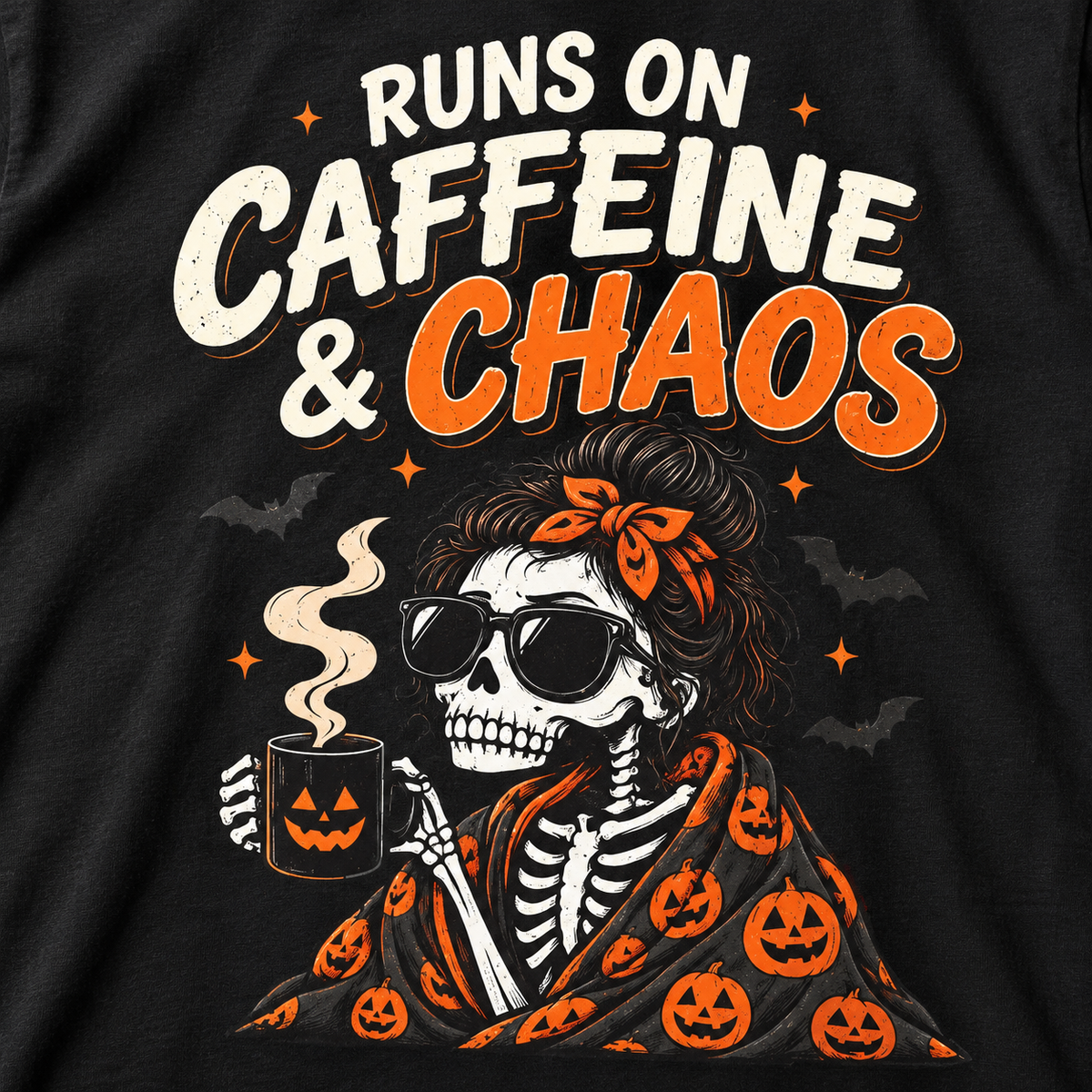 Print close-up of the "Runs on Caffeine & Chaos" skeleton coffee Halloween T-shirt by SarcasmArt in Black: skeleton woman with messy bun, bandana and sunglasses sipping from a jack-o'-lantern mug in a pumpkin blanket under RUNS ON CAFFEINE & CHAOS.