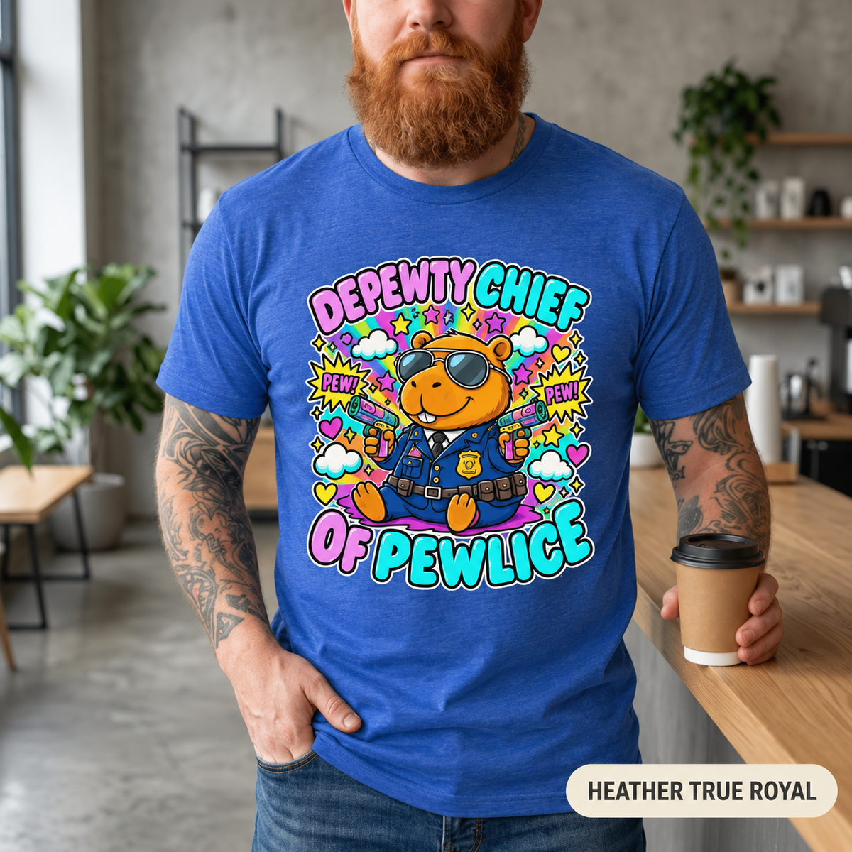 Bearded man with a coffee in a café wearing the "Depewty Chief of Pewlice" capybara meme T-shirt by SarcasmArt in Heather True Royal (heathered royal blue).