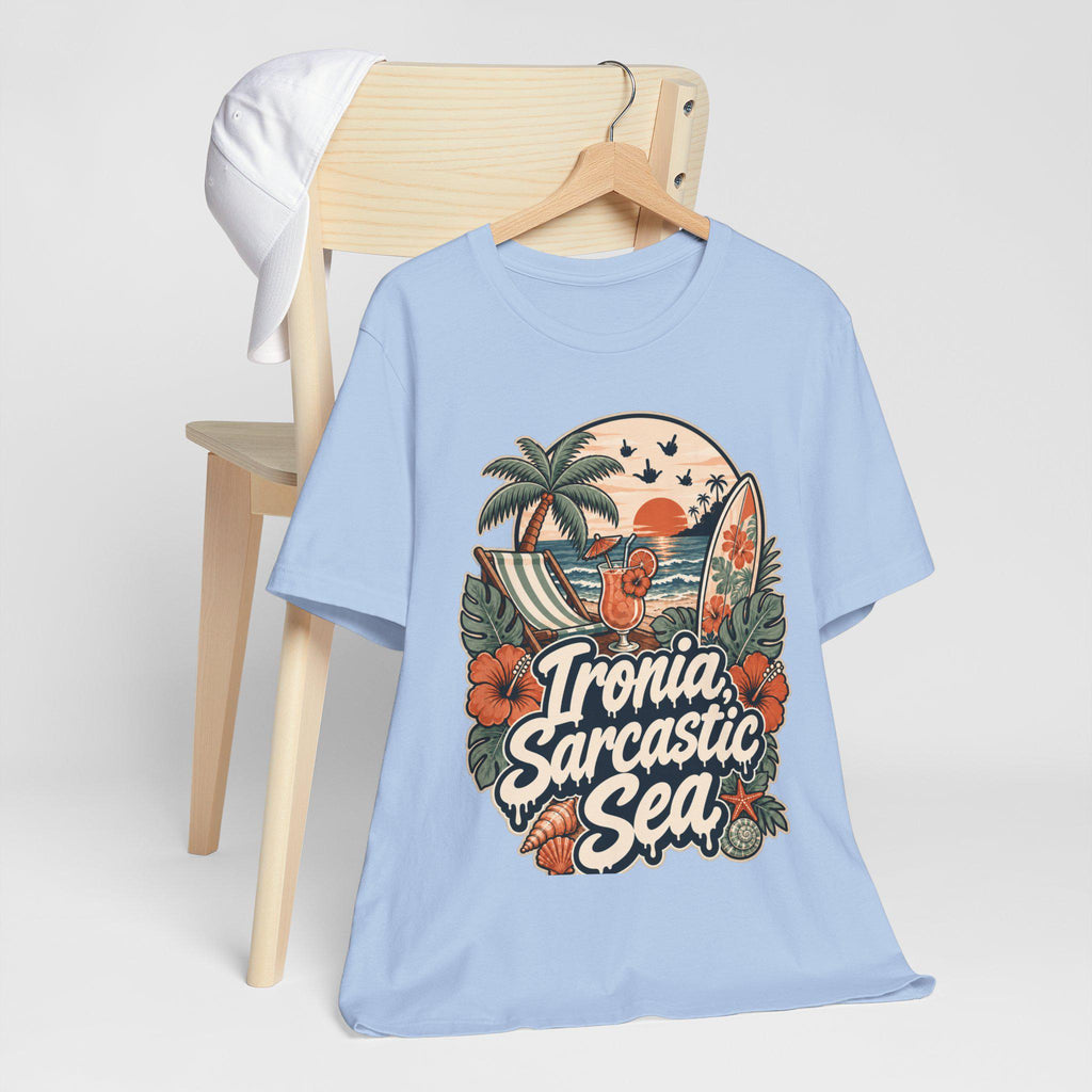 The "Ironia, Sarcastic Sea" retro beach T-shirt by SarcasmArt in light blue hanging on a wooden chair.