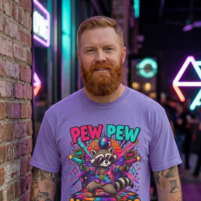 Bearded man in front of a neon-lit brick wall wearing the "Pew Pew Madafakas" raccoon meme T-shirt by SarcasmArt in Violet.