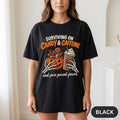 Woman wearing the "Surviving on Candy & Caffeine" Halloween mom T-shirt by SarcasmArt in Black.