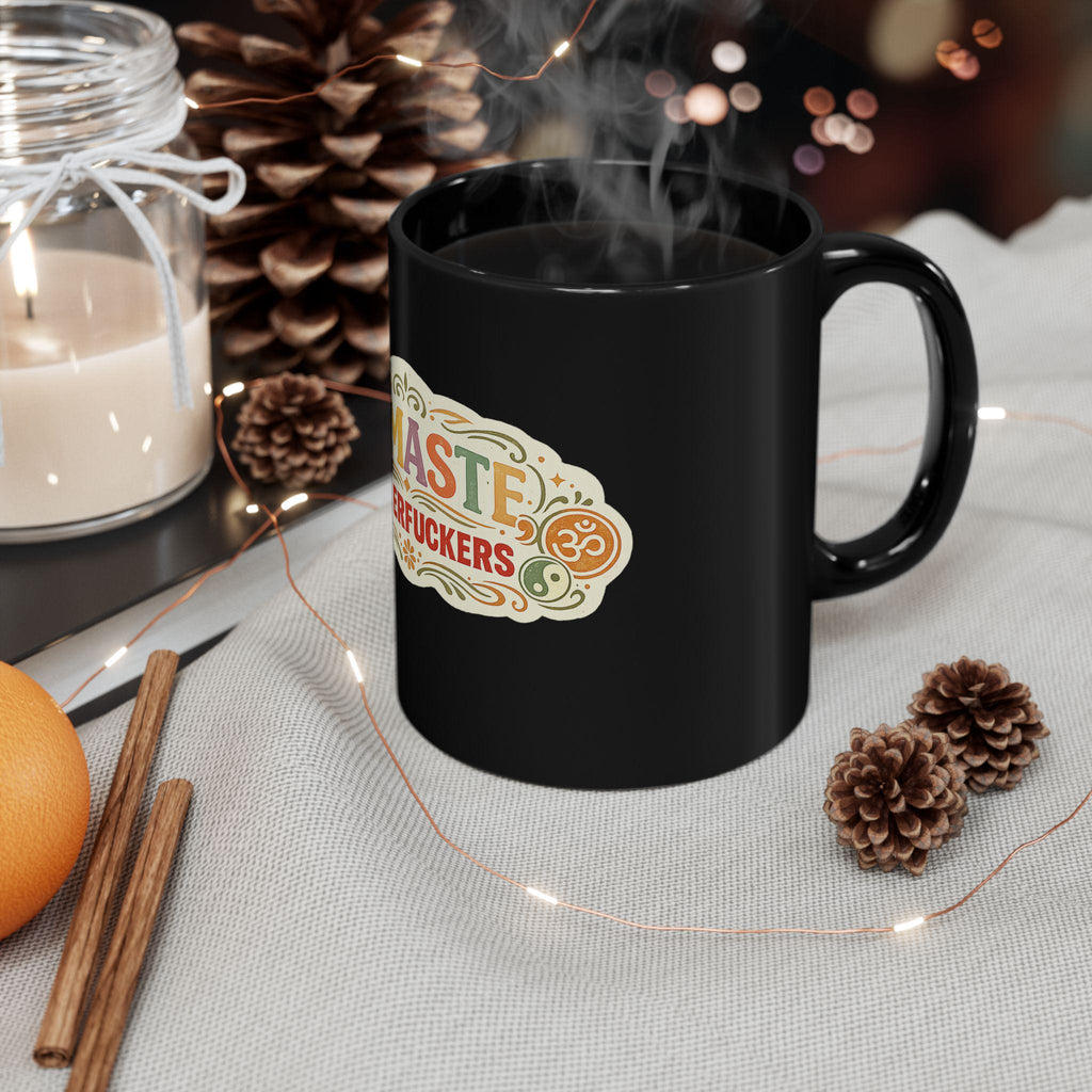 The "Namaste Motherfuckers" funny yoga coffee mug by SarcasmArt steaming with hot coffee in a cozy winter setting with pine cones and cinnamon sticks.