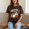 Woman sitting on a bench wearing the "Ghosting My To-Do List" retro Halloween procrastinator T-shirt by SarcasmArt in Dark Chocolate.