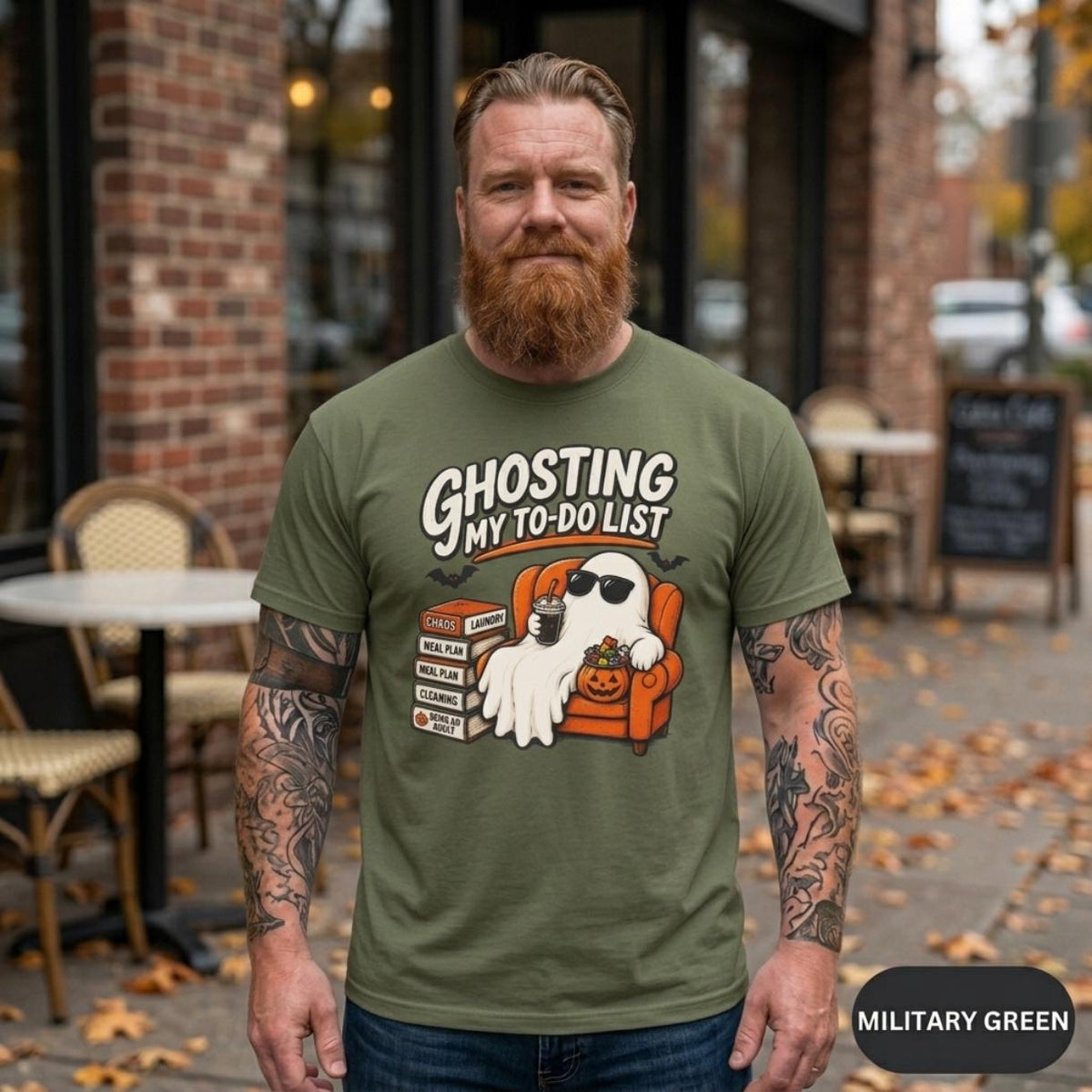 Bearded man on an autumn street wearing the "Ghosting My To-Do List" retro Halloween procrastinator T-shirt by SarcasmArt in Military Green.