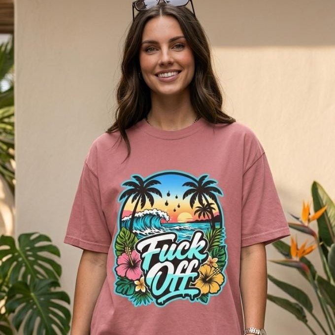 Woman in sunglasses on a beach boardwalk wearing the "F*ck Off" retro tropical beach T-shirt by SarcasmArt in Mauve.