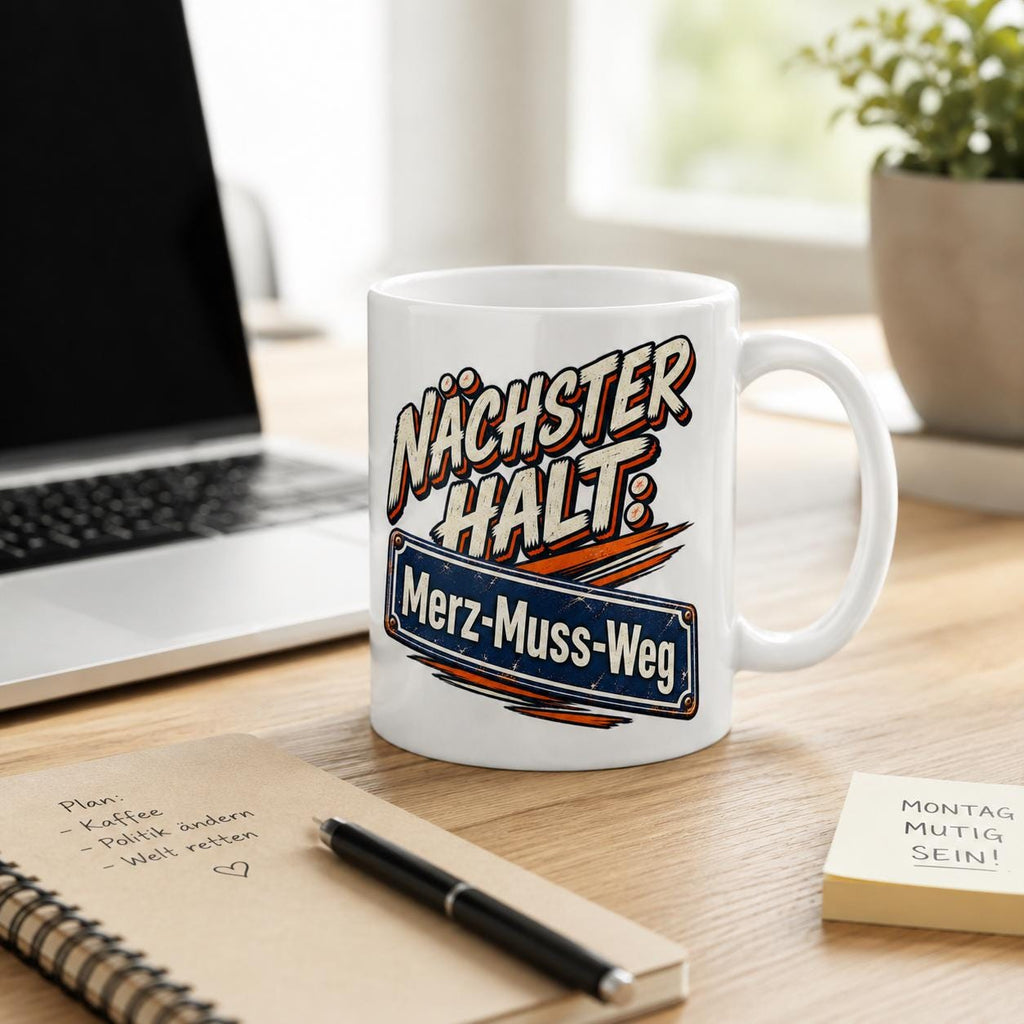 The "Nächster Halt: Merz-Muss-Weg" German political satire coffee mug by SarcasmArt on an office desk with a notebook and pen – a satirical gift for political humor fans in Germany.