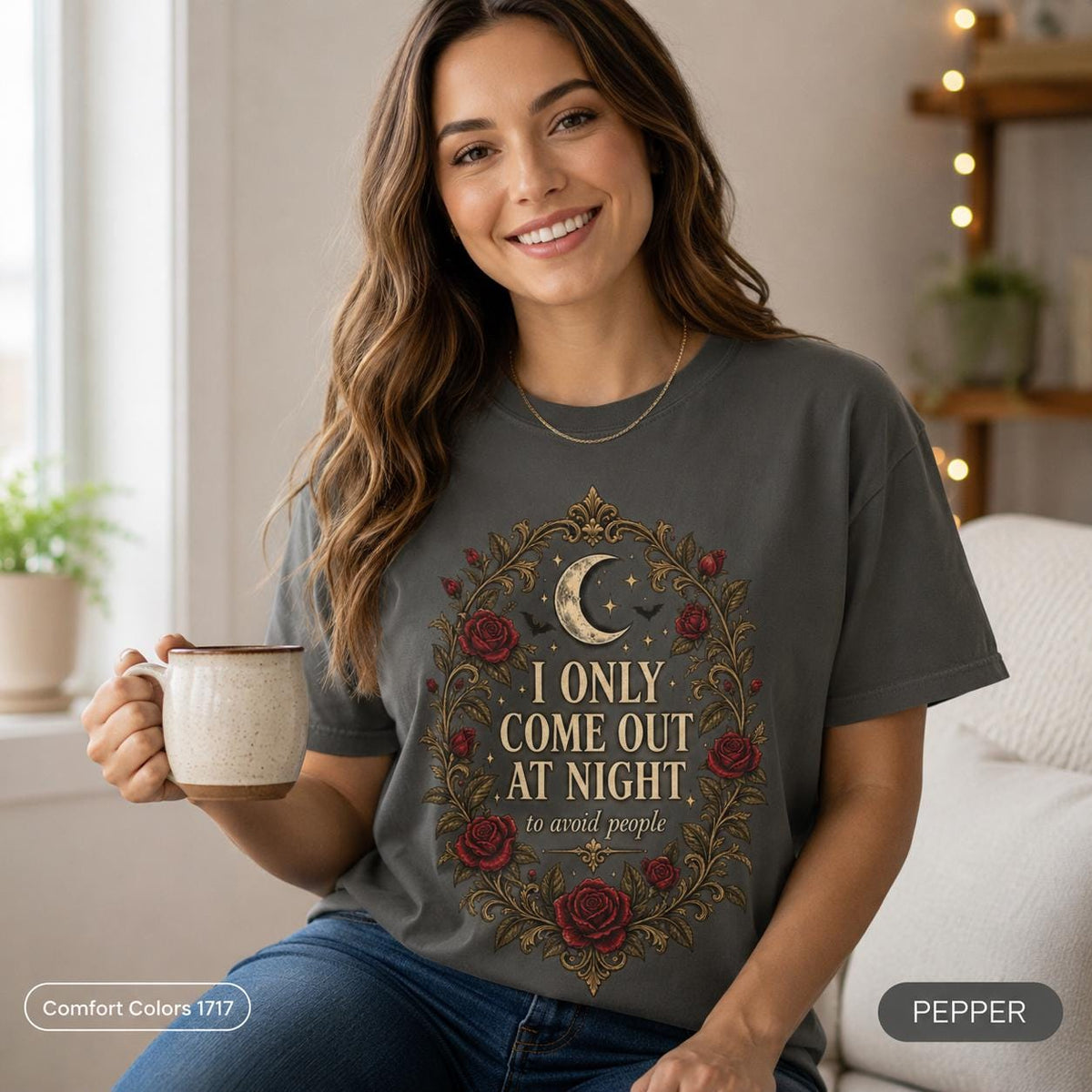 Woman holding a coffee mug wearing the "I Only Come Out at Night" romantic gothic vampire T-shirt by SarcasmArt in Pepper (washed charcoal) – a dark academia and gothic gift.