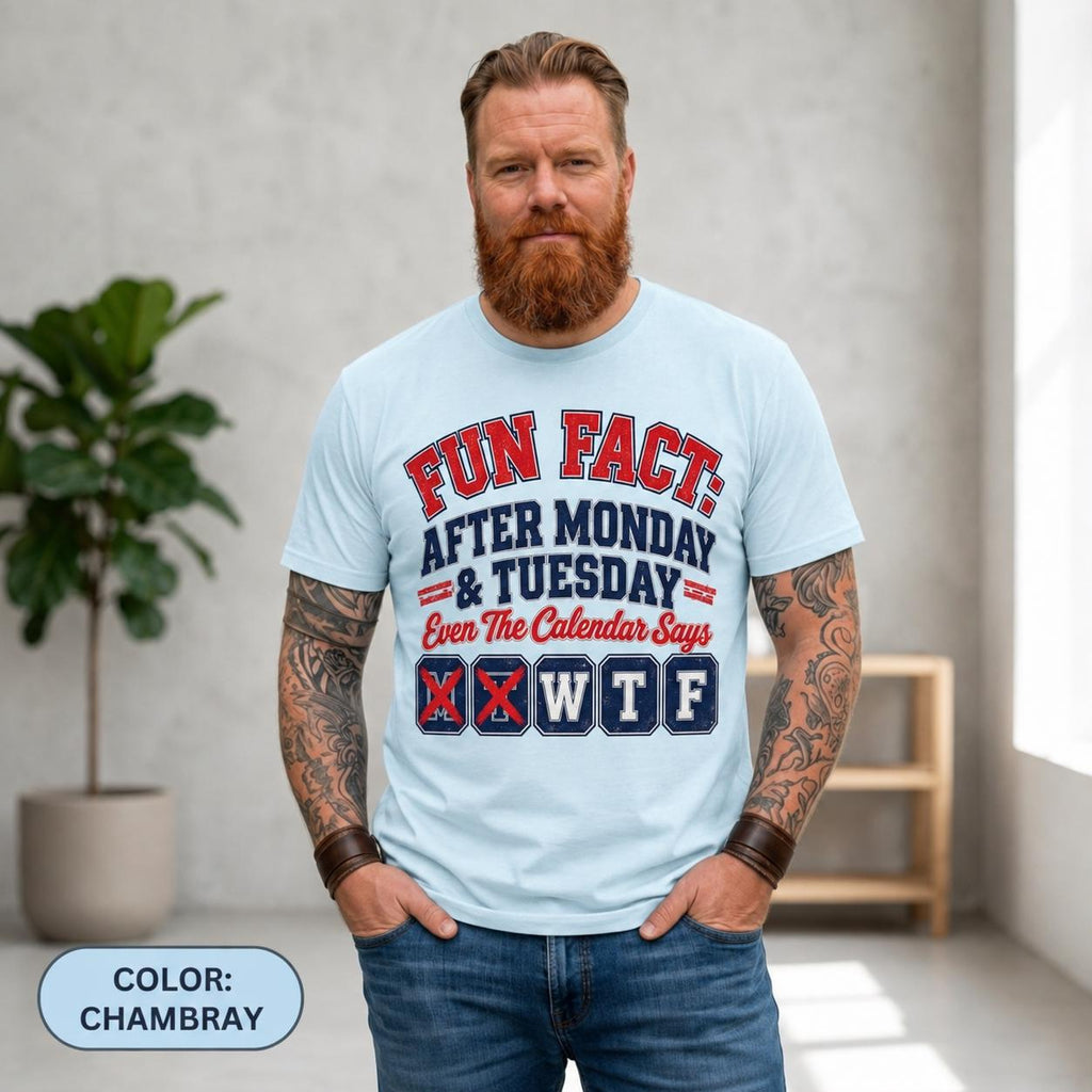 Bearded man in jeans wearing the "Fun Fact: After Monday & Tuesday" WTF varsity work T-shirt by SarcasmArt in Chambray (light blue), a funny office humor shirt.
