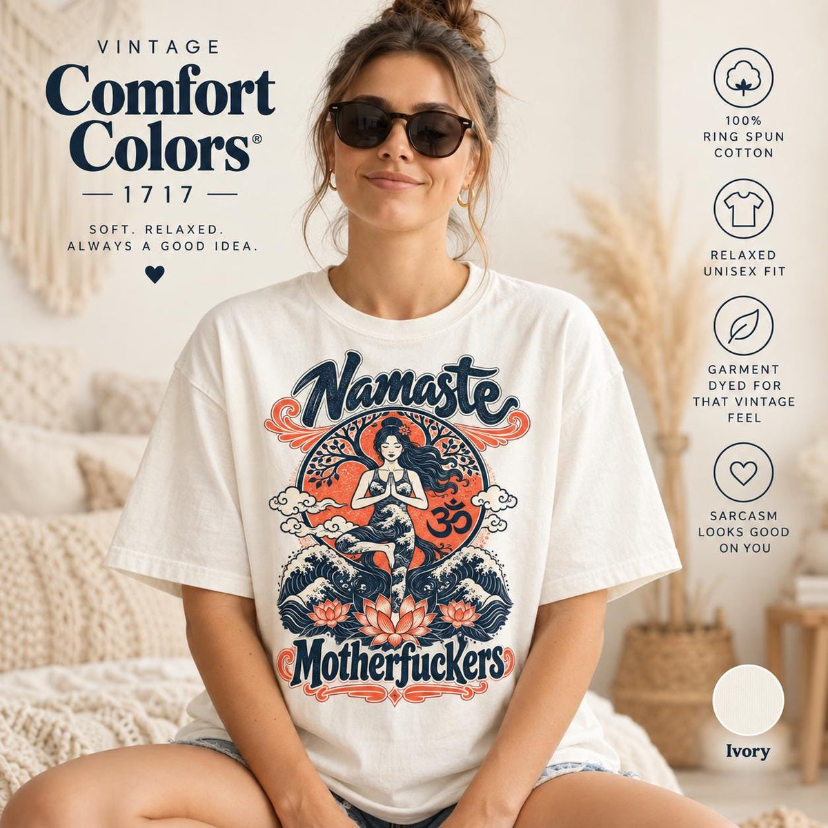 Woman in sunglasses in a boho living room wearing the "Namaste Motherfuckers" funny yoga T-shirt by SarcasmArt in Ivory – a vintage Comfort Colors 1717 tee with a meditating woman in lotus pose among red lotus flowers and navy waves with the script words Namaste and Motherfuckers.