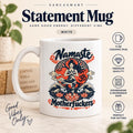 Statement mug: the white 11 oz glossy ceramic "Namaste Motherfuckers" funny yoga coffee mug by SarcasmArt with a meditating woman in lotus pose among red lotus flowers and navy waves with the script words Namaste and Motherfuckers.