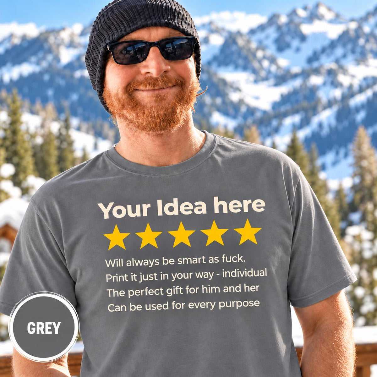 Bearded man in a beanie and sunglasses in front of snowy mountains wearing the personalized golden 5-star review T-shirt by SarcasmArt in Grey, with your custom title, five golden stars and four lines of your own review text in white.