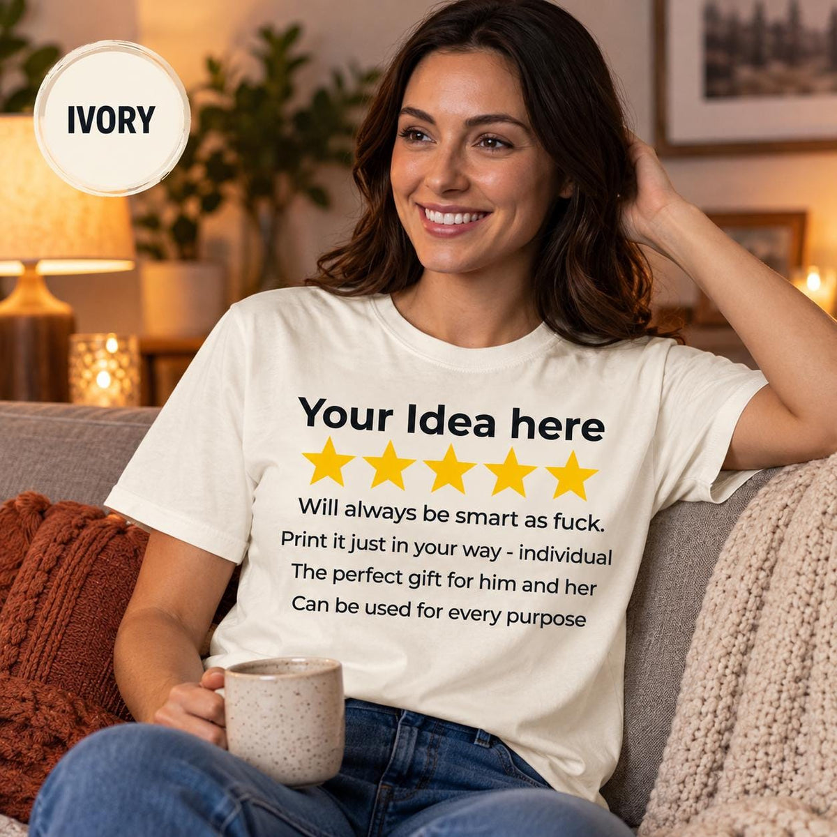 Smiling woman with a coffee on a sofa wearing the personalized golden 5-star review T-shirt for light colors by SarcasmArt in Ivory – a personalized gift for her.