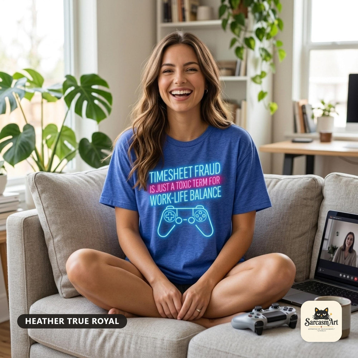 Laughing woman on a sofa wearing the "Timesheet Fraud Is Just a Toxic Term for Work-Life Balance" neon gamer T-shirt by SarcasmArt in Heather True Royal.