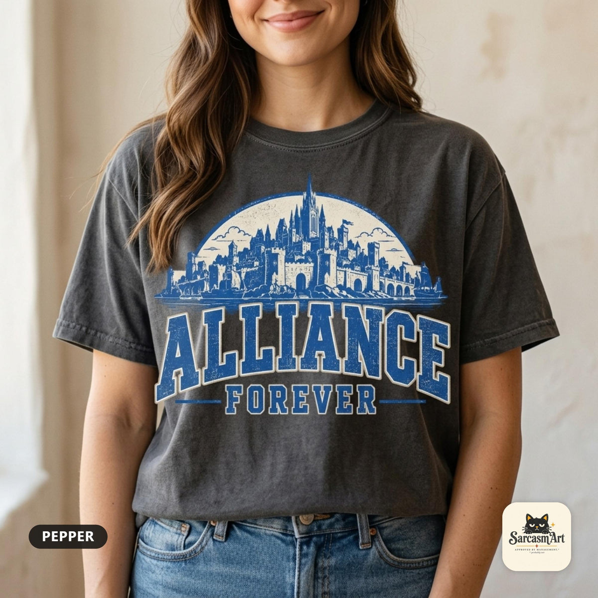 Close-up of the "Alliance Forever" World of Warcraft gamer T-shirt in Pepper (washed charcoal) by SarcasmArt, worn by a woman in jeans: blue distressed ALLIANCE FOREVER varsity lettering under a fantasy city skyline printed large on the chest.
