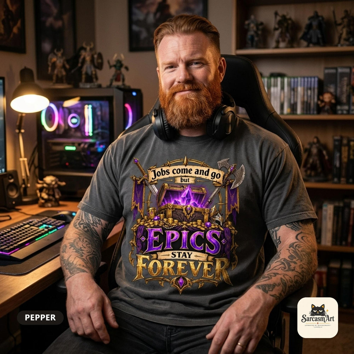 Bearded man at his gaming desk with figurine shelves wearing the "Epics Stay Forever" funny gamer T-shirt in Pepper (washed charcoal) – a Comfort Colors 1717 unisex tee by SarcasmArt with the quote "Jobs come and go but EPICS STAY FOREVER" above a glowing purple loot chest in a gold fantasy frame with crossed axes.