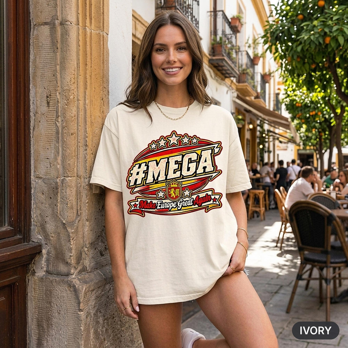 Smiling woman at a European street café wearing the "#MEGA Make Europe Great Again" Spain T-shirt by SarcasmArt in Ivory.