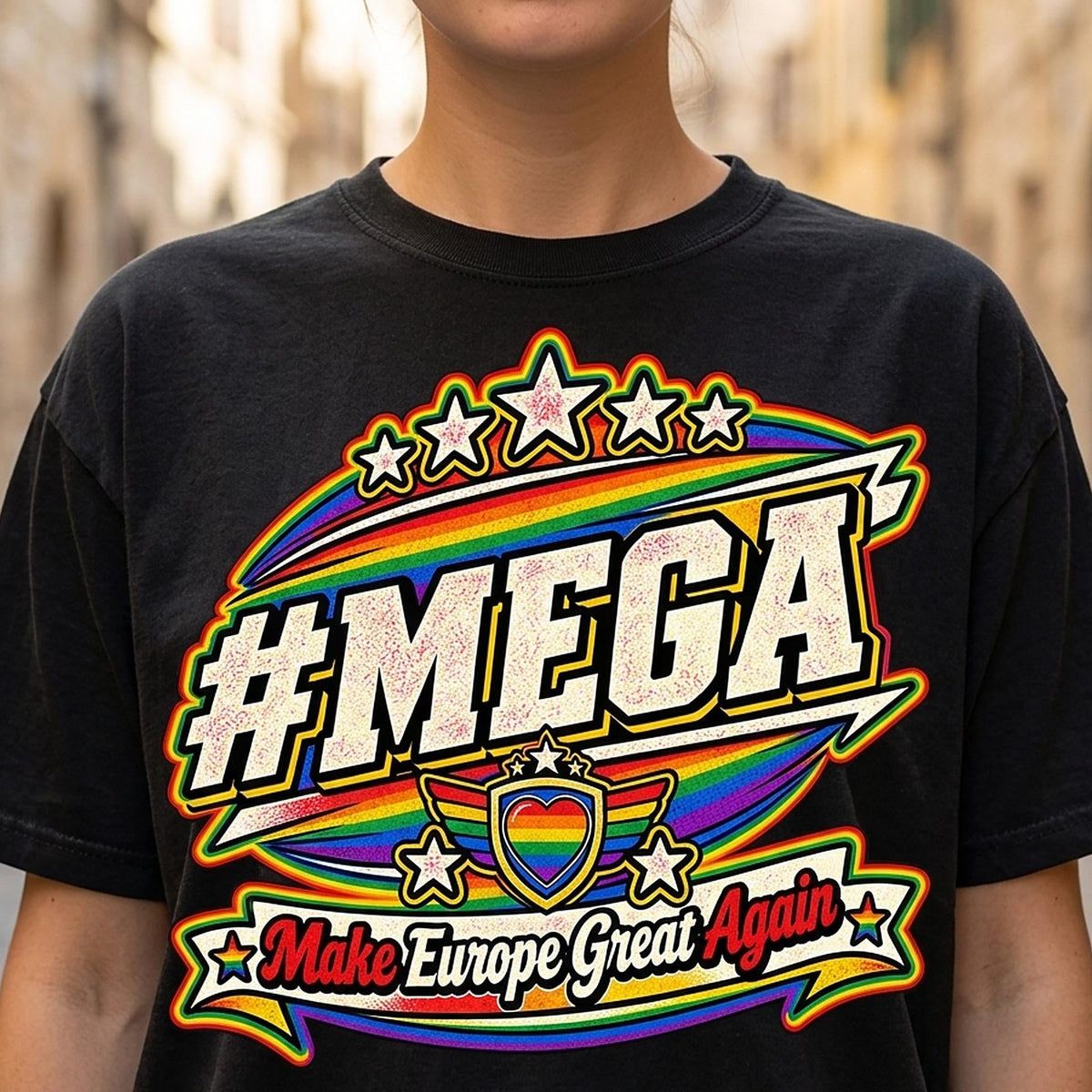Close-up of the "#MEGA Make Europe Great Again" Rainbow Pride T-shirt by SarcasmArt in Black: a retro #MEGA sports badge with rainbow pride stripes, a rainbow heart shield, stars and a Make Europe Great Again script banner, printed large on a garment-dyed Comfort Colors 1717 tee.