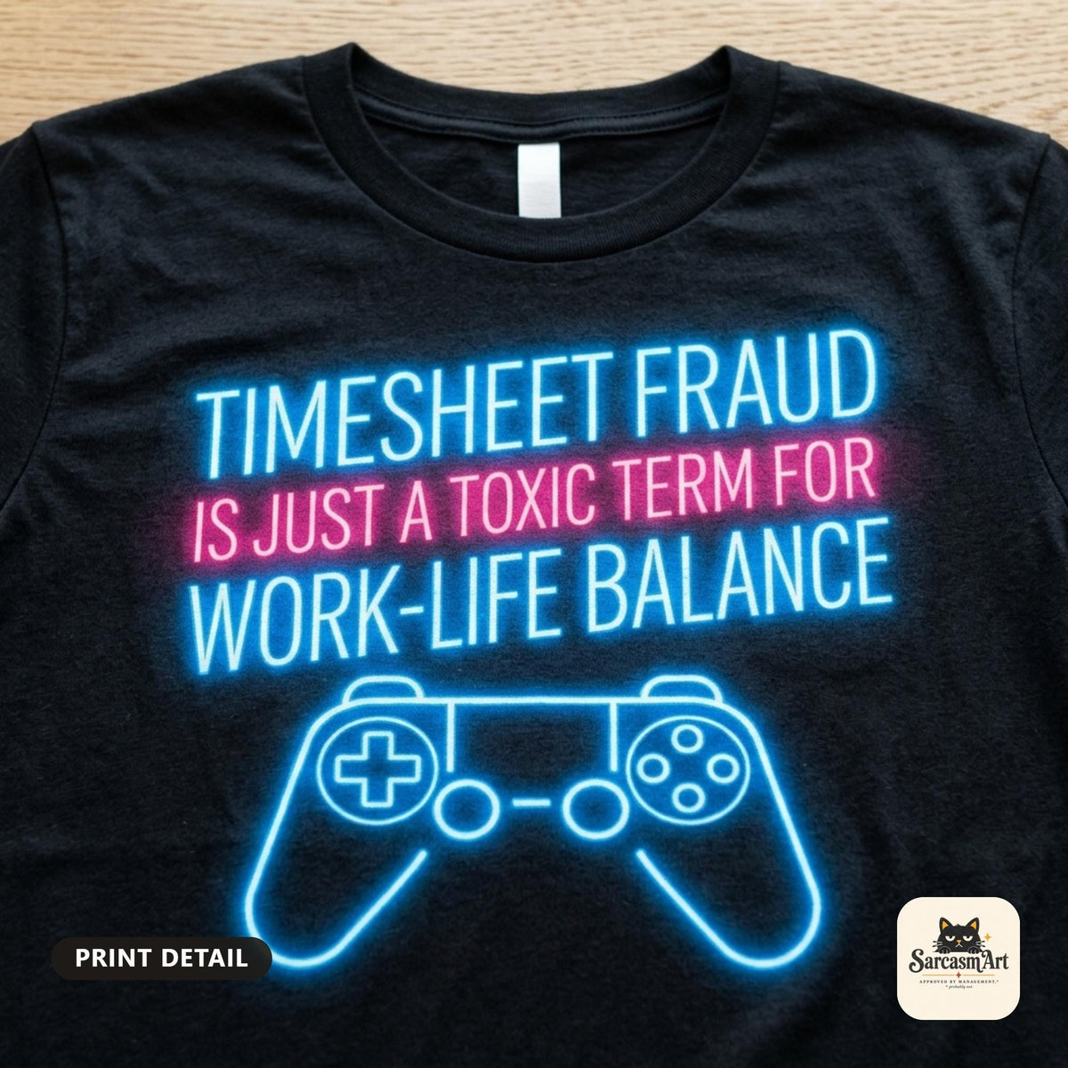Print detail of the "Timesheet Fraud Is Just a Toxic Term for Work-Life Balance" neon gamer T-shirt by SarcasmArt on Black: glowing neon blue and pink lettering TIMESHEET FRAUD IS JUST A TOXIC TERM FOR WORK-LIFE BALANCE above a neon game controller.