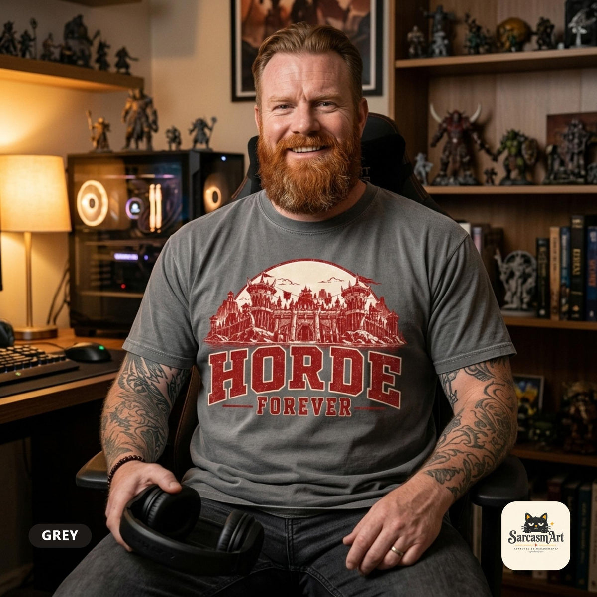 Bearded man in his gaming room with figurine shelves wearing the "Horde Forever" World of Warcraft gamer T-shirt in Grey – a Comfort Colors 1717 unisex tee by SarcasmArt with red distressed HORDE FOREVER varsity lettering over a gothic fantasy castle skyline.