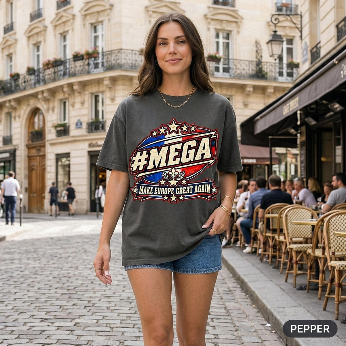 Woman on a cobblestone street in Paris wearing the "#MEGA Make Europe Great Again" France T-shirt by SarcasmArt in Pepper – a satirical #MEGA collection shirt with a retro #MEGA sports badge with the blue-white-red French tricolore, a fleur-de-lis emblem with laurel, stars and a MAKE EUROPE GREAT AGAIN banner.