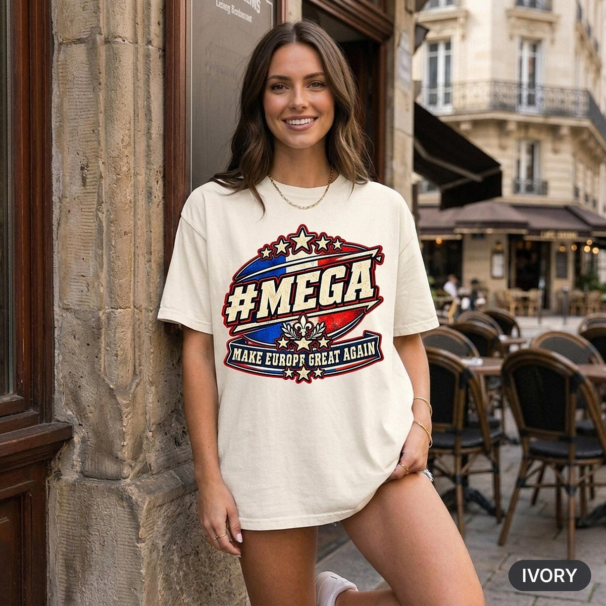 Smiling woman at a European street café wearing the "#MEGA Make Europe Great Again" France T-shirt by SarcasmArt in Ivory.