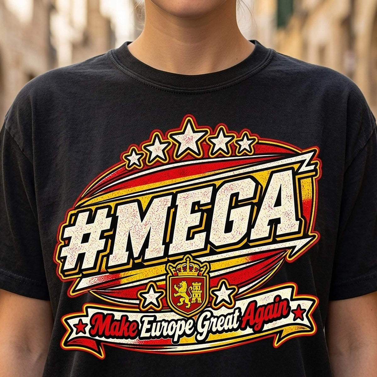Close-up of the "#MEGA Make Europe Great Again" Spain T-shirt by SarcasmArt in Black: a retro #MEGA sports badge with the red-yellow Spanish flag stripes, a crowned lion shield, stars and a Make Europe Great Again script banner, printed large on a garment-dyed Comfort Colors 1717 tee.