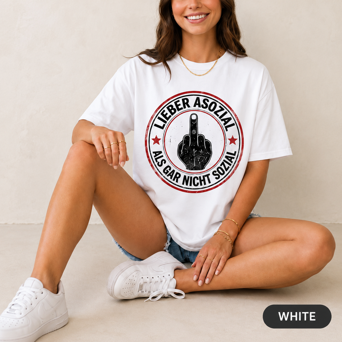 Woman sitting on the floor wearing the "Lieber asozial als gar nicht sozial" middle finger T-shirt by SarcasmArt in White – a German dark humor shirt with a round red-and-black badge with a middle finger hand.