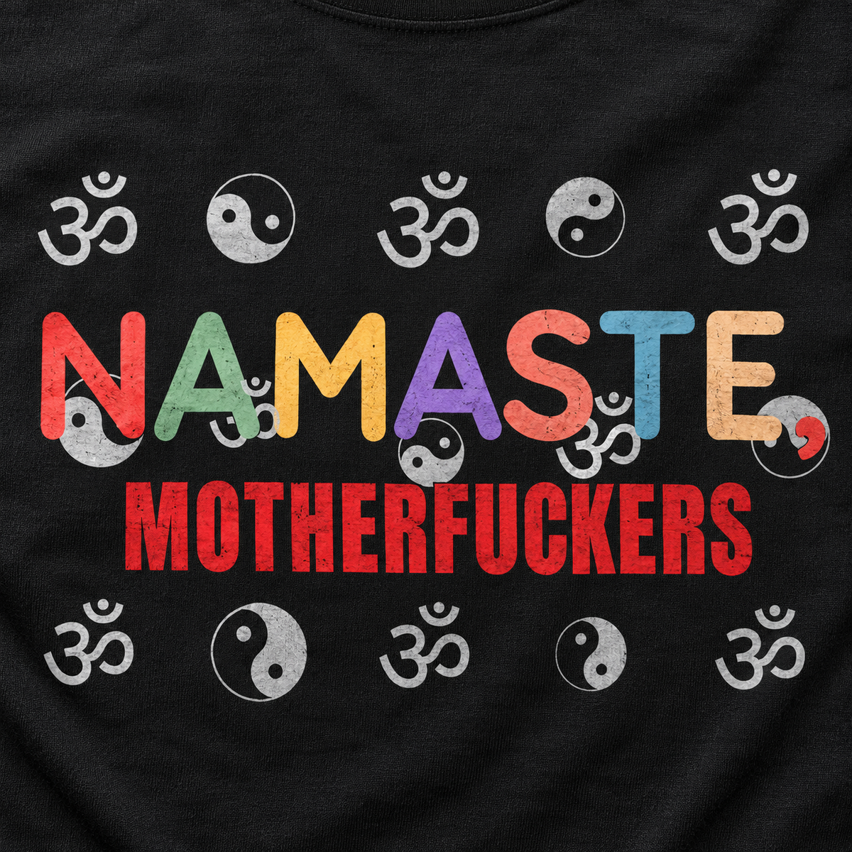 Print close-up of the "Namaste, Motherfuckers" funny yoga T-shirt by SarcasmArt in Black: multicolored NAMASTE lettering and red MOTHERFUCKERS framed by rows of om and yin-yang symbols.