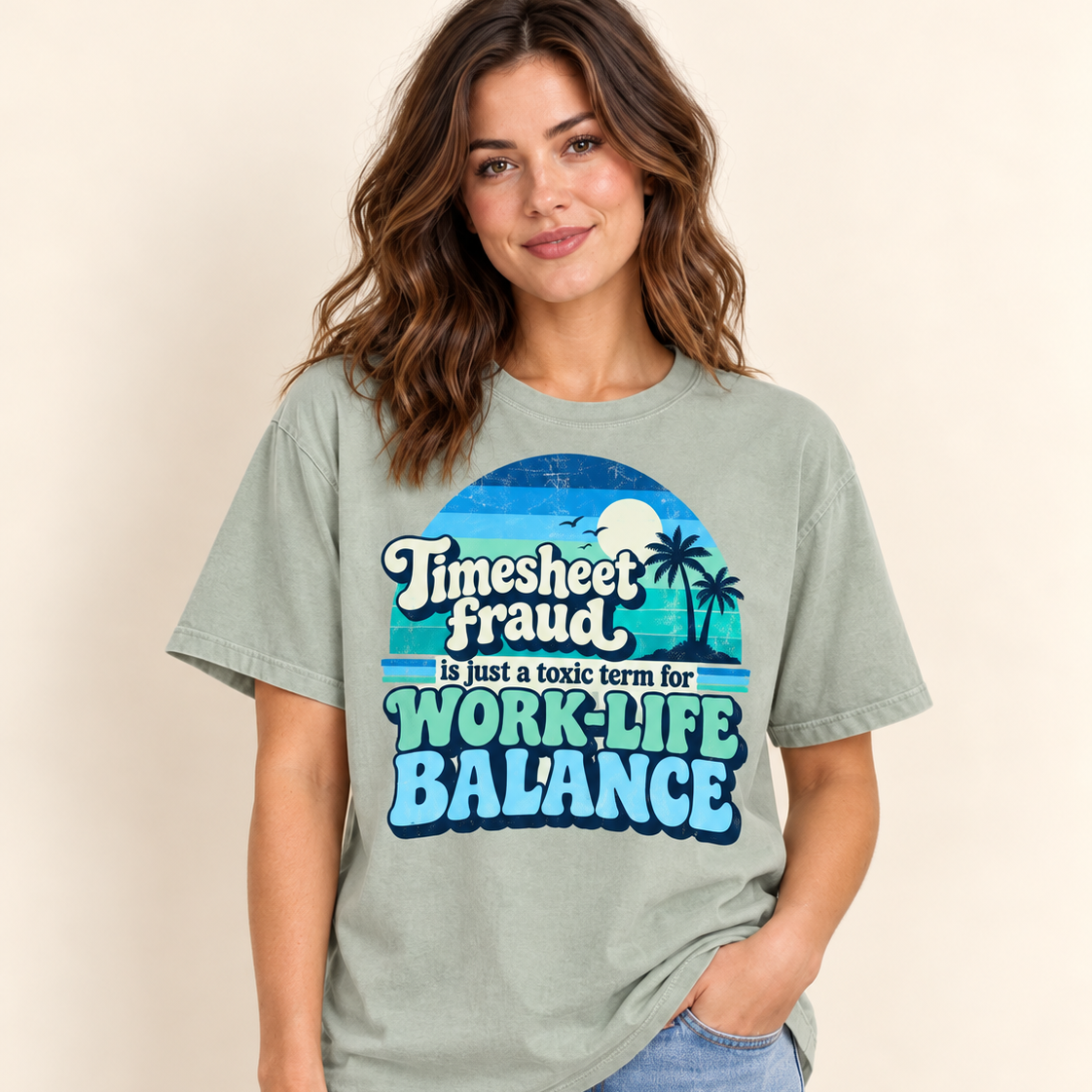 Smiling woman in jeans wearing the "Timesheet Fraud Is Just a Toxic Term for Work-Life Balance" sarcastic work T-shirt by SarcasmArt in Bay (sage green).